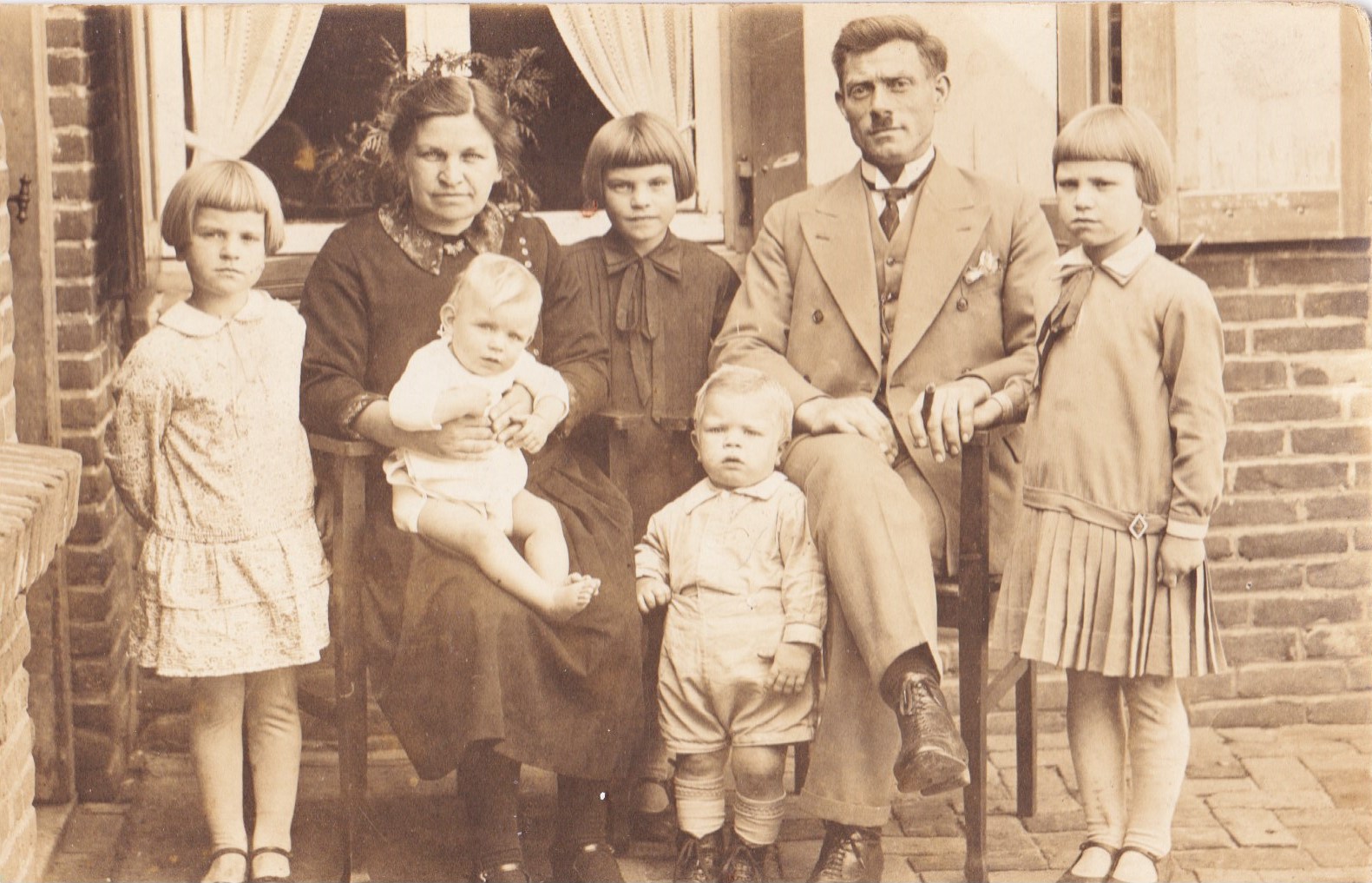 Klik voor foto in apart venster dekkers_janus__en_woutje_schoonus_met_hun_5_kinderen_achter_hun_huis_aan_de_parallelweg_4_in_helvoirt__ongeveer_1930.jpg